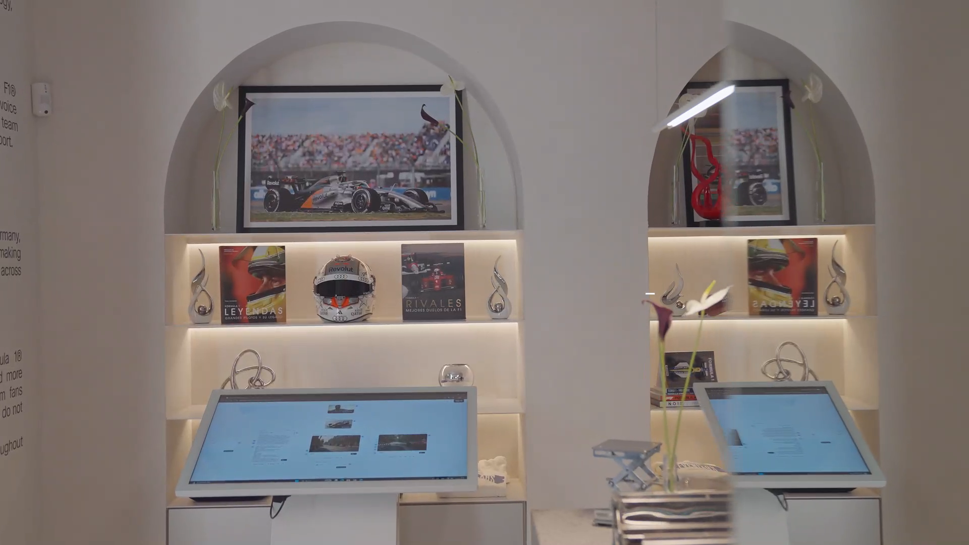 Arched display alcoves with illuminated shelving and interactive screens inside ElevenLabs Madrid