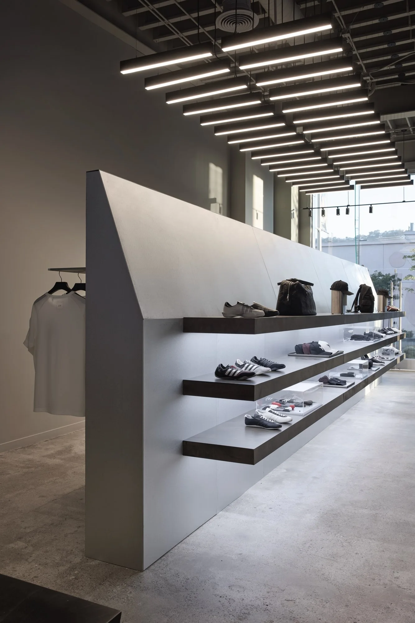 Completed Y-3 West Hollywood interior: sculptural shelving, footwear and suspended lighting