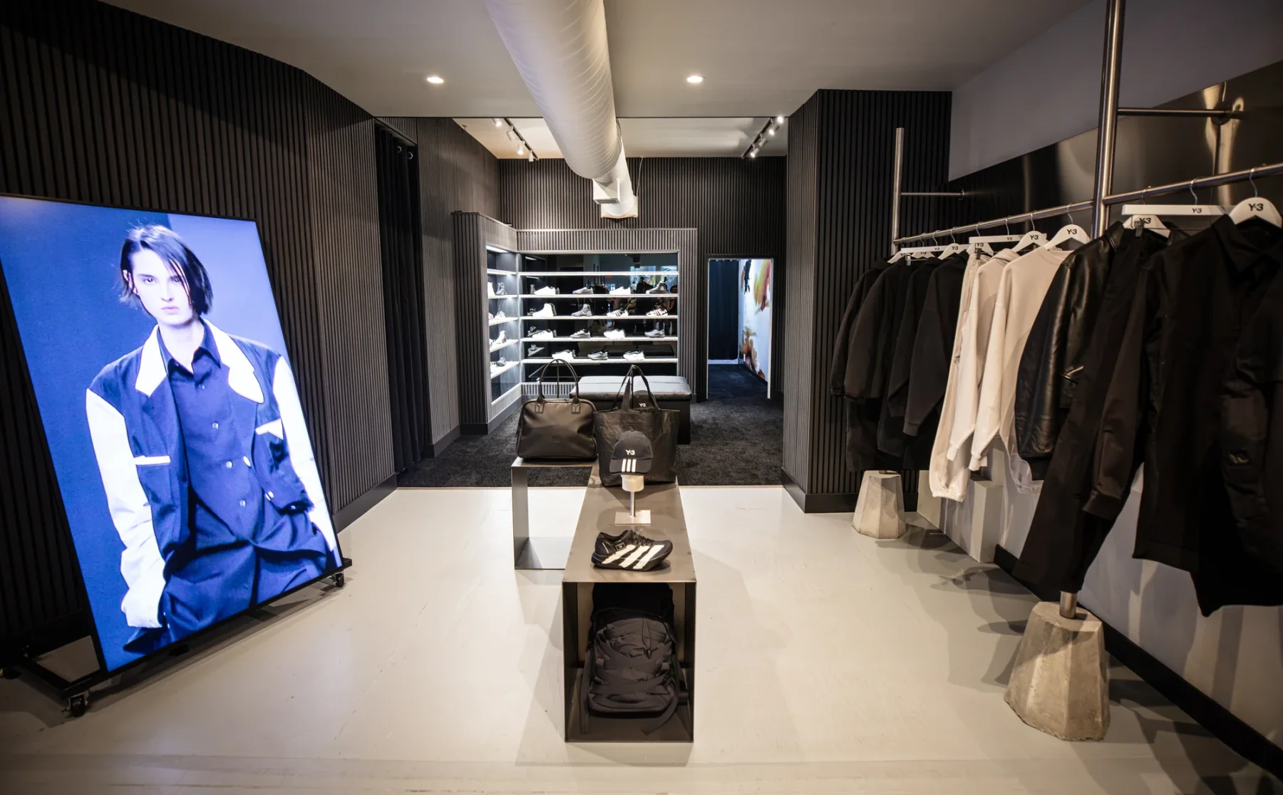 The Y-3 SoHo interior, connecting apparel rails, central displays and the illuminated footwear wall